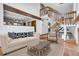 Cozy living room showcasing a staircase, plush sofa, stylish chair, and brick fireplace at 13270 W 65Th Ave, Arvada, CO 80004