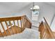 Carpeted stairway with wooden railing, chandelier, and window leading to the second floor at 13270 W 65Th Ave, Arvada, CO 80004