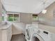 Well-lit laundry room with modern washer and dryer, storage cabinets, and view to the backyard at 549 N Ogden St, Denver, CO 80218
