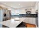 Modern kitchen with stainless steel appliances, white cabinets, and an island with seating at 8903 Edgewood St, Highlands Ranch, CO 80130