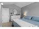 Cozy bedroom features a comfortable blue quilted bed, white dresser, and stylish round mirror at 2854 N Lowell Blvd, Denver, CO 80211