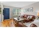 Inviting living room features hardwood floors, comfortable seating, and a beautiful blue entry door at 2854 N Lowell Blvd, Denver, CO 80211