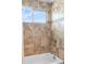 Tiled shower with a tub combination and clear window showcasing lots of natural light at 2854 N Lowell Blvd, Denver, CO 80211