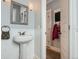 Charming powder room with pedestal sink, decorative mirror, and paneled walls at 201 S Logan St, Denver, CO 80209