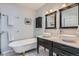 Elegant bathroom with a clawfoot tub, dual sinks, and black and white tiled floors at 201 S Logan St, Denver, CO 80209