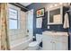 Bathroom featuring blue walls, white cabinets, and shower with white tiles at 201 S Logan St, Denver, CO 80209