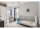 Bright room with a white crib, cushioned chair, and soft carpet at 201 S Logan St, Denver, CO 80209