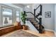 Inviting entryway with hardwood floors, staircase and a charming window bench with pillows at 201 S Logan St, Denver, CO 80209