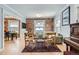 Cozy living room featuring hardwood floors, exposed brick accent wall, and natural light at 201 S Logan St, Denver, CO 80209