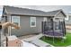 Exterior view of the backyard with artificial turf, a trampoline, seating and a patio with stone pillars at 9694 Truckee St, Commerce City, CO 80022