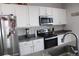 Bright kitchen featuring stainless steel appliances, white cabinetry, and ample counter space for a functional and stylish design at 9694 Truckee St, Commerce City, CO 80022