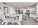 Modern kitchen and dining area with white cabinets, gray countertops, stainless steel appliances, and stone accents at 9694 Truckee St, Commerce City, CO 80022
