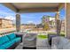 Covered patio space with comfortable seating, stone pillars, and a view of the landscaped yard and neighborhood at 9694 Truckee St, Commerce City, CO 80022
