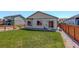 Spacious backyard with lush green grass, a privacy fence, and a patio area for outdoor enjoyment at 8861 Ventura St, Commerce City, CO 80022