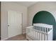 Charming Bedroom featuring a white crib and a playful painted arch on the accent wall at 8861 Ventura St, Commerce City, CO 80022