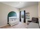 Bedroom with a white crib, comfortable chair, book shelves, and a view of the backyard at 8861 Ventura St, Commerce City, CO 80022
