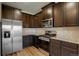 Spacious kitchen featuring stainless steel appliances, granite countertops, and dark brown cabinets at 8861 Ventura St, Commerce City, CO 80022