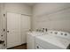 Functional laundry room with modern appliances, storage, and an adjacent closet at 8861 Ventura St, Commerce City, CO 80022