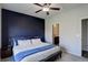A main bedroom features a ceiling fan, navy blue accent wall, and ensuite bathroom at 8861 Ventura St, Commerce City, CO 80022