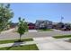 A street view of a quiet suburban neighborhood with well-maintained homes and green lawns at 8861 Ventura St, Commerce City, CO 80022