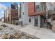 Modern townhouse with stone landscaping, gated front patio and muted gray, red and brown color palette at 2922 W 26Th Ave # 1, Denver, CO 80211