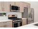Close-up of kitchen features stainless steel appliances and light wood cabinetry with white backsplash at 2922 W 26Th Ave # 1, Denver, CO 80211