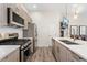Modern kitchen features stainless steel appliances, light wood cabinetry, and a central island with a sink at 2922 W 26Th Ave # 1, Denver, CO 80211