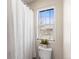 Clean bathroom with shower, toilet, and a bright window with blinds at 9804 Martin Luther King Blvd, Denver, CO 80238