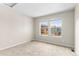 An empty room with two windows, carpet, and neutral colored walls at 9804 Martin Luther King Blvd, Denver, CO 80238