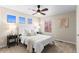 Bedroom featuring three windows, neutral carpet, bedside tables, and a ceiling fan at 9804 Martin Luther King Blvd, Denver, CO 80238