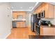 Well-lit kitchen with stainless steel appliances, wood cabinets, and a spacious layout at 9804 Martin Luther King Blvd, Denver, CO 80238