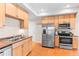 Well-lit kitchen featuring stainless steel appliances, wooden cabinets, and a double sink at 9804 Martin Luther King Blvd, Denver, CO 80238