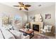 Cozy living room featuring a fireplace, ceiling fan, plush seating, and multiple bright windows at 9804 Martin Luther King Blvd, Denver, CO 80238