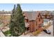 Aerial view of a red brick home with a tile roof, surrounded by mature trees and a fenced yard at 1763 N Williams St # 101, Denver, CO 80218