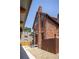 Exterior view of a brick building featuring a side porch, mature trees, and a fenced yard at 1763 N Williams St # 101, Denver, CO 80218