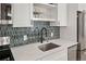 A modern kitchen features stainless steel appliances, quartz countertops, and stylish backsplash at 1763 N Williams St # 101, Denver, CO 80218