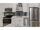 Modern kitchen with stainless steel appliances, subway tile backsplash, and white cabinetry at 1763 N Williams St # 101, Denver, CO 80218
