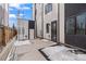 A modern townhome has a back entrance and patio with snowy concrete, along with a sleek design at 1254 Yates St, Denver, CO 80204