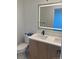 A modern bathroom featuring a dual sink vanity with a light wood finish and an illuminated mirror at 1254 Yates St, Denver, CO 80204