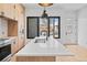 Bright kitchen with stainless appliances, island with white countertop, and natural wood cabinetry at 1254 Yates St, Denver, CO 80204