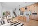 A modern open-concept living space featuring hardwood floors, a stylish kitchen island, and sleek black pendant lighting at 1254 Yates St, Denver, CO 80204