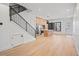 An open-concept space with modern kitchen, a staircase with a black railing, and hardwood floors at 1254 Yates St, Denver, CO 80204