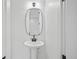 Elegant powder room with a pedestal sink, and modern mirror at 1254 Yates St, Denver, CO 80204