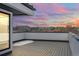A rooftop deck offers panoramic views of the city skyline and distant mountains at sunset at 1254 Yates St, Denver, CO 80204