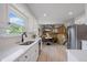 Bright, open kitchen with white cabinets, stainless steel appliances, and an adjacent dining area at 10961 Gray Cir, Westminster, CO 80020