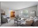 Bright living room featuring a large window, plush seating, and a warm wood door at 10961 Gray Cir, Westminster, CO 80020
