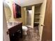 Cozy bathroom featuring a sink with vanity, a cabinet, a toilet, and tiled floors at 13187 E Bethany Pl, Aurora, CO 80014