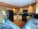 Kitchen featuring light wood cabinets, hardwood floors, stainless steel sink, and black appliances at 13187 E Bethany Pl, Aurora, CO 80014