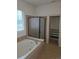 Bathroom featuring a soaking tub and walk-in closet at 11811 E Maplewood Ave, Englewood, CO 80111