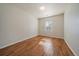 Clean, light-filled bedroom with hardwood floors, a single window, and neutral walls at 11811 E Maplewood Ave, Englewood, CO 80111
